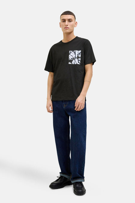 Zwart T-shirt met korte mouwen van ORIGINALS BY JACK & JONES, met bloemenprint zak, gedragen met een blauwe jeans en zwarte schoenen.