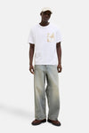 Wit T-shirt met korte mouwen van ORIGINALS BY JACK & JONES met abstracte opgedrukte zak, gedragen met een spijkerbroek en een pet.
