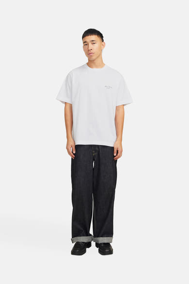 Wit T-shirt met korte mouwen van Originals by Jack & Jones, gedragen met een opgerolde donkere broek en zwarte schoenen.