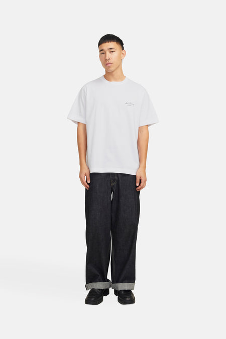 Wit T-shirt met korte mouwen van Originals by Jack & Jones, gedragen met een opgerolde donkere broek en zwarte schoenen.
