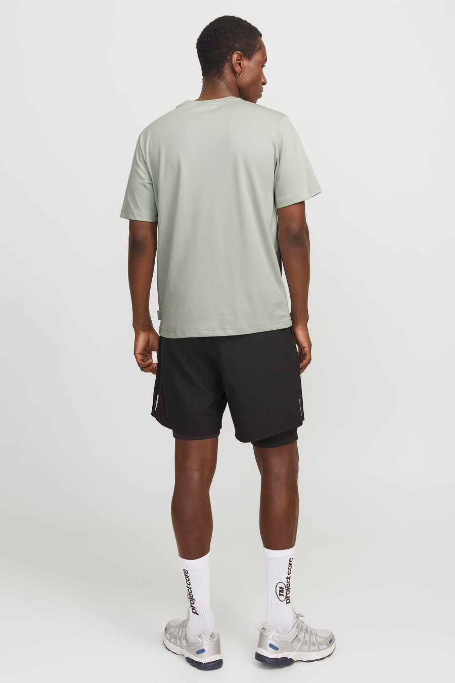 Groen T-shirt met korte mouwen van JACK & JONES, gedragen met een zwarte sportbroek en zilveren hardloopschoenen.