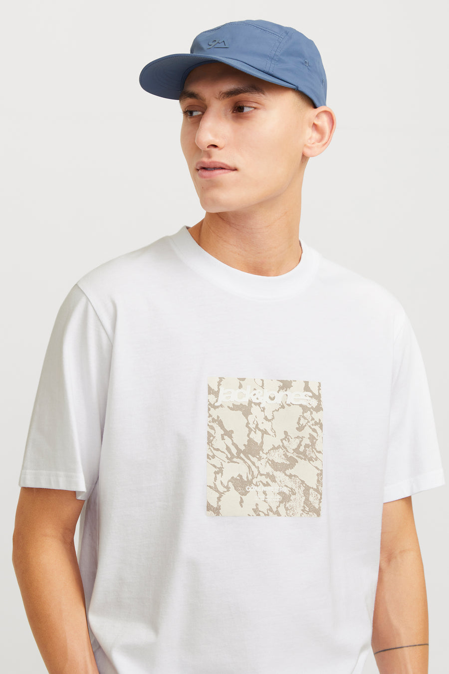 Wit T-shirt met korte mouwen van ORIGINALS BY JACK & JONES, met opdruk op de voorkant en gedragen met een blauwe pet.