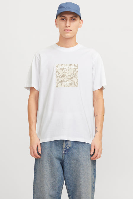 Wit T-shirt met korte mouwen, van ORIGINALS BY JACK & JONES, met een camouflageprint op de voorkant, gedragen met een blauwe jeans en een blauwe pet.