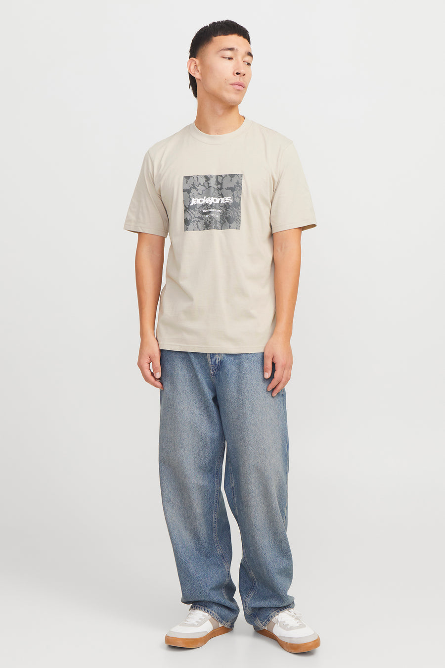 Beige T-shirt met korte mouwen van ORIGINALS BY JACK & JONES, met vierkant grafisch patroon op de voorkant, gedragen met een wijde jeans.