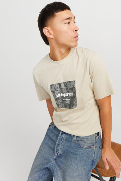 Beige T-shirt met korte mouwen van ORIGINALS BY JACK & JONES, met grafische print op de voorkant, gedragen met een blauwe jeans.