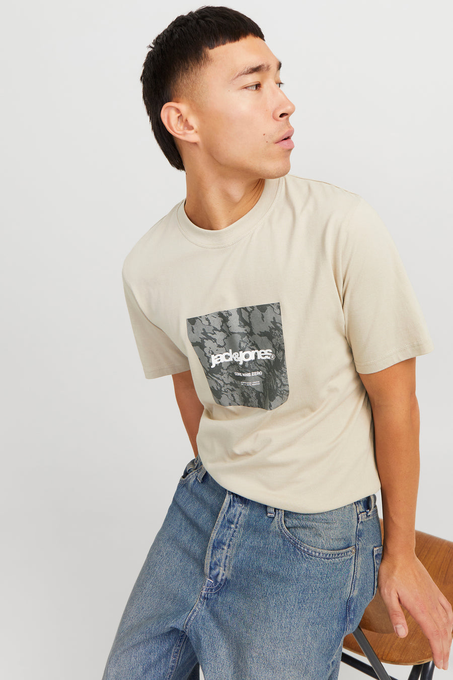 Beige T-shirt met korte mouwen van ORIGINALS BY JACK & JONES, met grafische print op de voorkant, gedragen met een blauwe jeans.