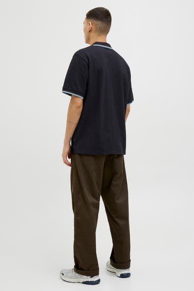 Zwart poloshirt met korte mouwen van JACK & JONES, met blauwe gestreepte kraag en zomen, gedragen met een bruine broek.