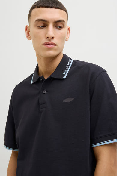 Zwart poloshirt met korte mouwen van JACK & JONES, met lichtblauwe strepen op de kraag en mouwen.