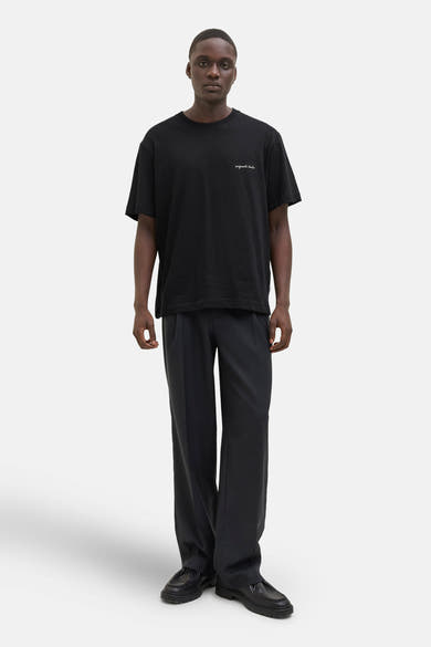 Zwart T-shirt met korte mouwen van ORIGINALS BY JACK & JONES gedragen met een zwarte wijde broek en zwarte schoenen.
