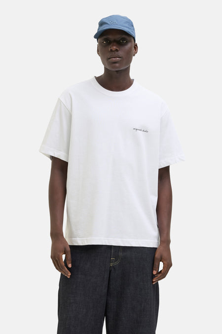 Wit T-shirt met korte mouwen van ORIGINALS BY JACK & JONES, gedragen met een wijde spijkerbroek en een pet.