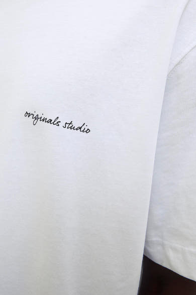 Wit T-shirt met korte mouwen van ORIGINALS BY JACK & JONES met zwarte handgeschreven tekst op de voorkant.