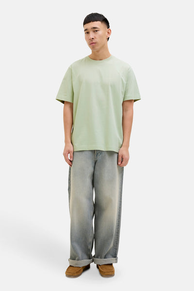 T-shirt à manches courtes vert de ORIGINALS BY JACK & JONES, porté avec un jean ample et des chaussures marron.