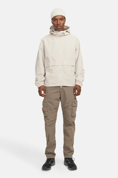 Korte beige jas van JACK & JONES, met capuchon en bruine cargobroek.