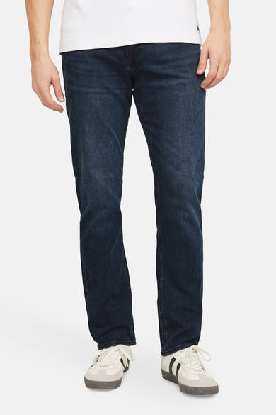 Rechte donkerblauwe spijkerbroek van JACK & JONES JEANS INTELLIGENCE, gedragen met een wit T-shirt en sneakers.