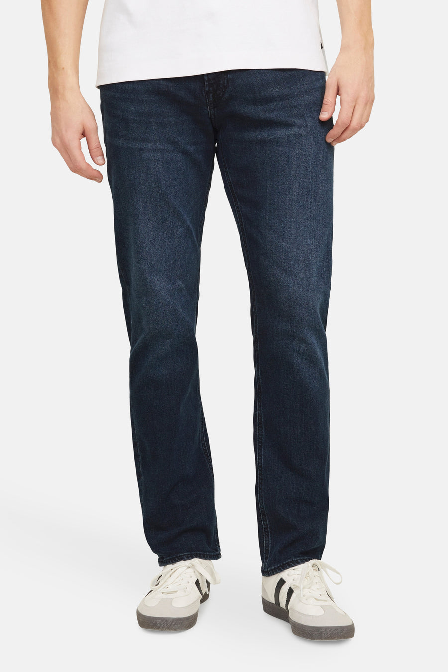 Rechte donkerblauwe spijkerbroek van JACK & JONES JEANS INTELLIGENCE, gedragen met een wit T-shirt en sneakers.