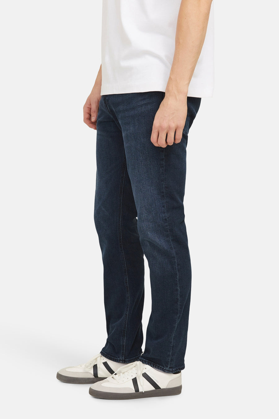 Rechte donkerblauwe jeans van JACK & JONES JEANS INTELLIGENCE, gedragen met witte sportschoenen.