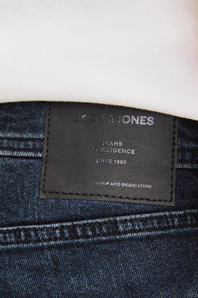 Rechte donkerblauwe jeans van JACK & JONES JEANS INTELLIGENCE, met een zwart leren etiket aan de achterkant en zichtbare stiksels.