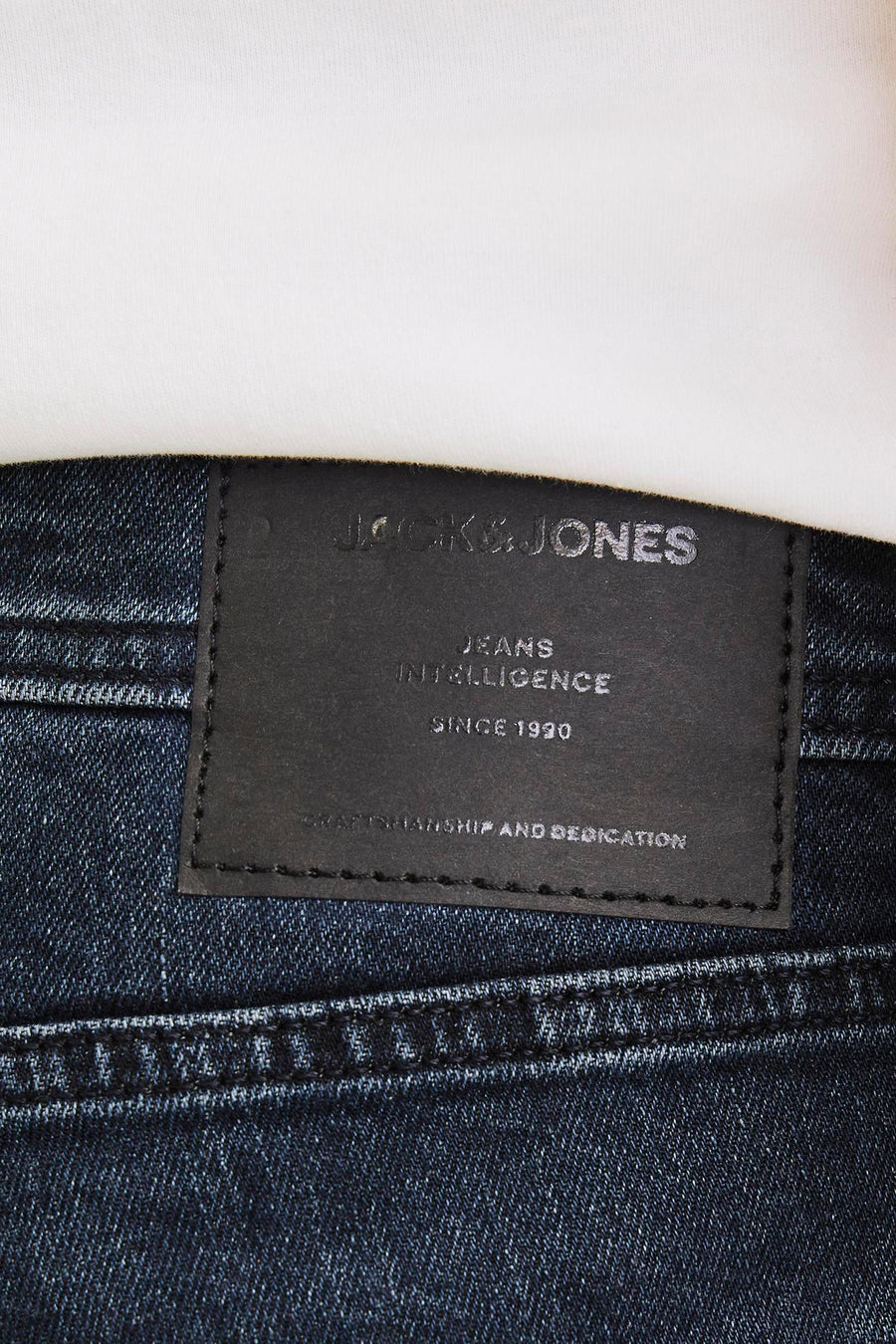 Rechte donkerblauwe jeans van JACK & JONES JEANS INTELLIGENCE, met een zwart leren etiket aan de achterkant en zichtbare stiksels.