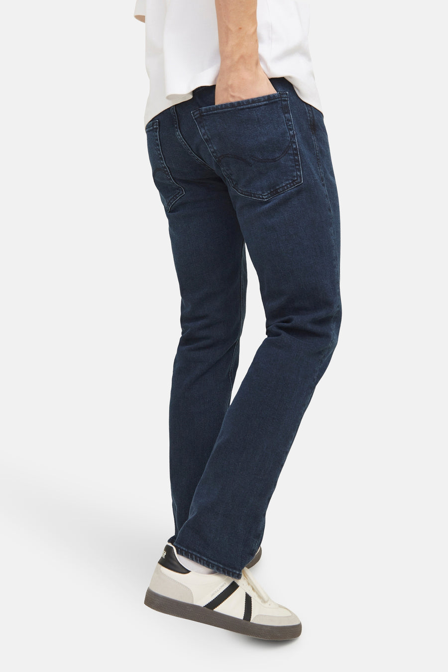 Rechte donkerblauwe jeans van JACK & JONES JEANS INTELLIGENCE, gedragen met een wit T-shirt en retro sneakers.