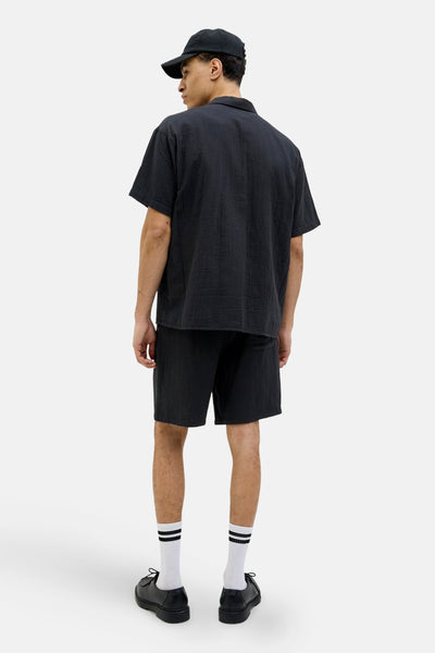 Korte noir van ORIGINALS BY JACK & JONES, gedragen met gestreepte witte sokken en zwarte schoenen.