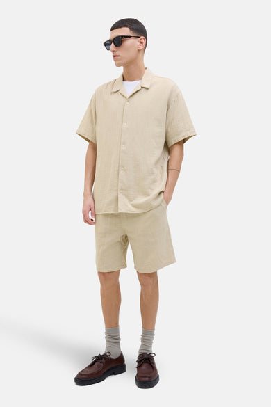 Korte beige van ORIGINALS BY JACK & JONES, gedragen met een beige overhemd en bruine schoenen.