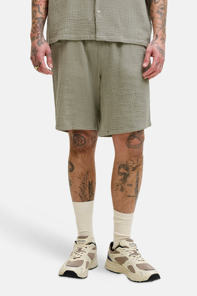 Short vert en gaze de coton par ORIGINALS BY JACK & JONES, avec des tatouages et des baskets.