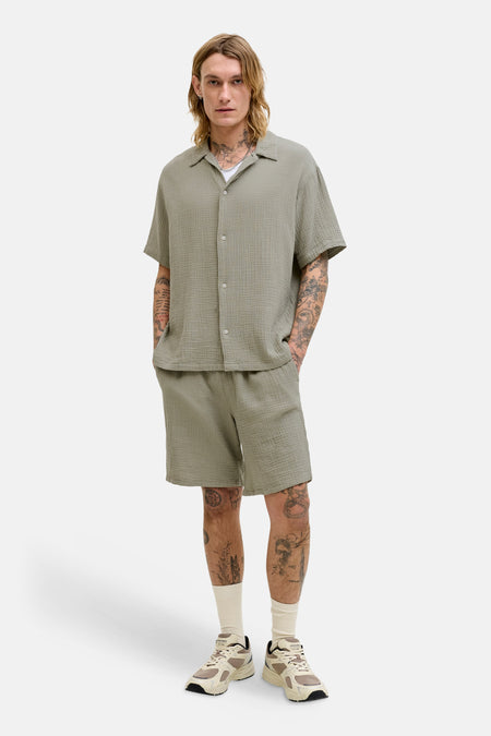 Kort vest van ORIGINALS BY JACK & JONES, kreukelige textuur, gedragen met een bijpassend overhemd, sokken en sneakers.