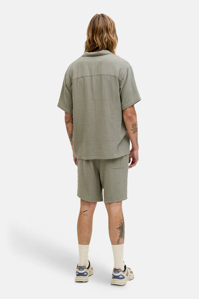 Short vert en texture gaufrée, de ORIGINALS BY JACK & JONES, porté avec des chaussettes couleur crème et des baskets.