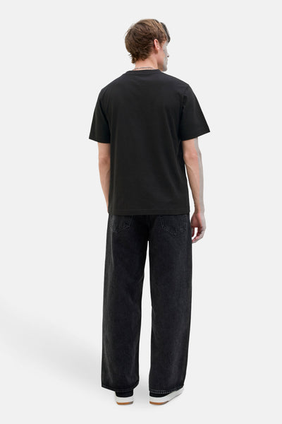 Zwarte t-shirt met korte mouwen van JACK & JONES, gedragen met een brede zwarte broek en witte sneakers, rugweergave.