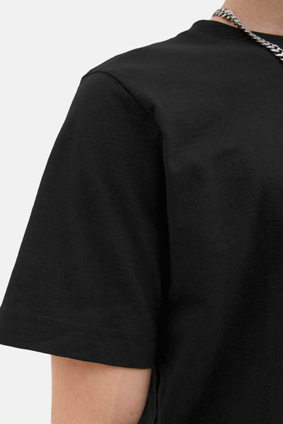 T-shirt noir à manches courtes de JACK & JONES, avec une chaîne argentée visible au niveau du col.