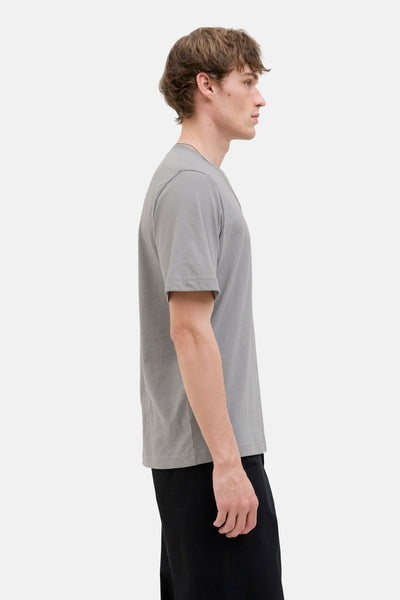 Grijze T-shirt met korte mouwen van JACK & JONES, gedragen met een zwarte broek, zijaanzicht.