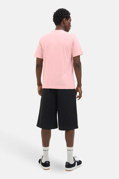 T-shirt à manches courtes rose de JACK & JONES, porté avec un short noir et des chaussures de sport.