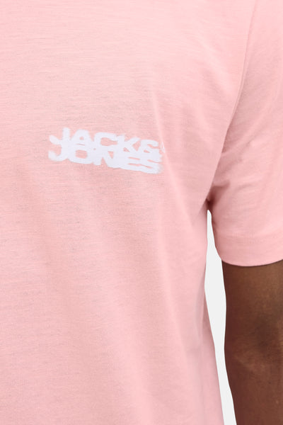 T-shirt rose à manches courtes de JACK & JONES avec un motif blanc, porté sur une personne.