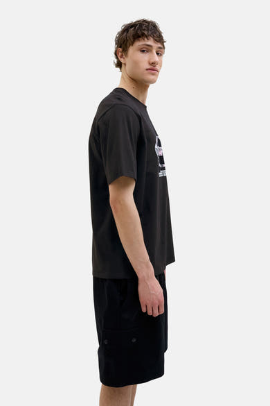 T-shirt noir à manches courtes de ORIGINALS BY JACK & JONES, avec motif imprimé, porté avec un short noir.