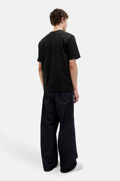 Zwarte korte mouw T-shirt van ORIGINALS BY JACK & JONES, gedragen met een donkere brede jeans en witte sneakers.