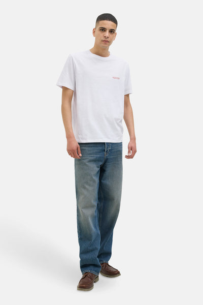 T-shirt blanc à manches courtes de Jack & Jones, porté avec un jean bleu et des chaussures marron.