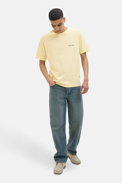 T-shirt jaune à manches courtes de JACK & JONES, porté avec un jean bleu et des chaussures en daim.