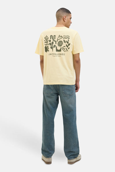 Geel T-shirt met korte mouwen van JACK & JONES, met grafische print op de rug, gedragen met een blauwe jeans.