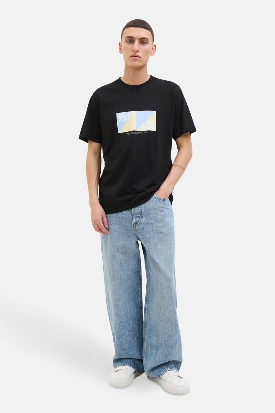 T-shirt noir à manches courtes de ORIGINALS BY JACK & JONES, avec motif imprimé rectangulaire sur le devant, porté avec un jean ample.