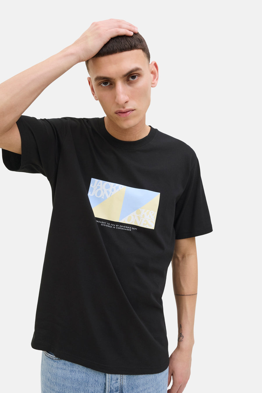 T-shirt à manches courtes noir de ORIGINALS BY JACK & JONES, avec imprimé graphique sur le devant, porté avec un jean.
