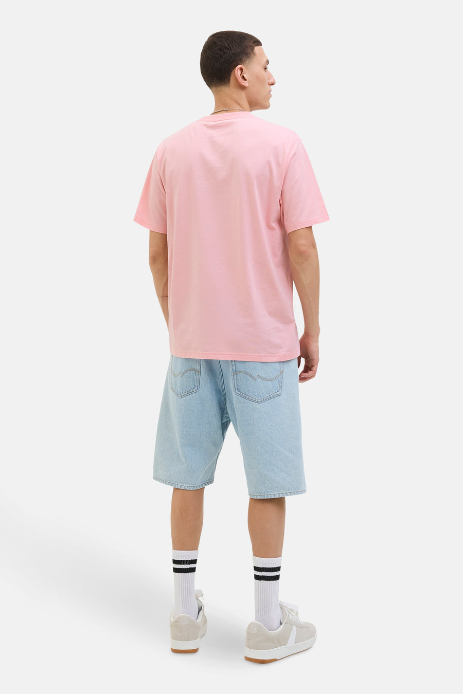 Roze T-shirt met korte mouwen, van ORIGINALS BY JACK & JONES, gedragen met een lichtblauwe spijkerbroek en sneakers.