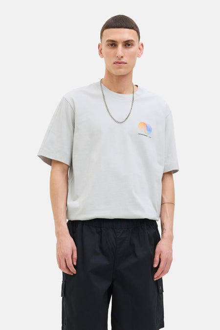 Grijs T-shirt met korte mouwen van JACK & JONES, met een grafische print op de voorkant, gedragen met een zilveren ketting.