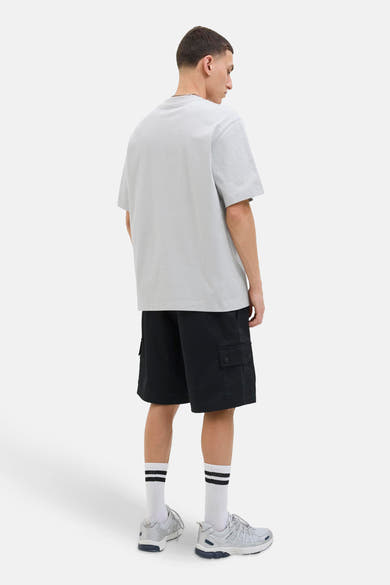 Grijs T-shirt met korte mouwen van JACK & JONES, gedragen met een zwarte cargoshort en zilveren sneakers.