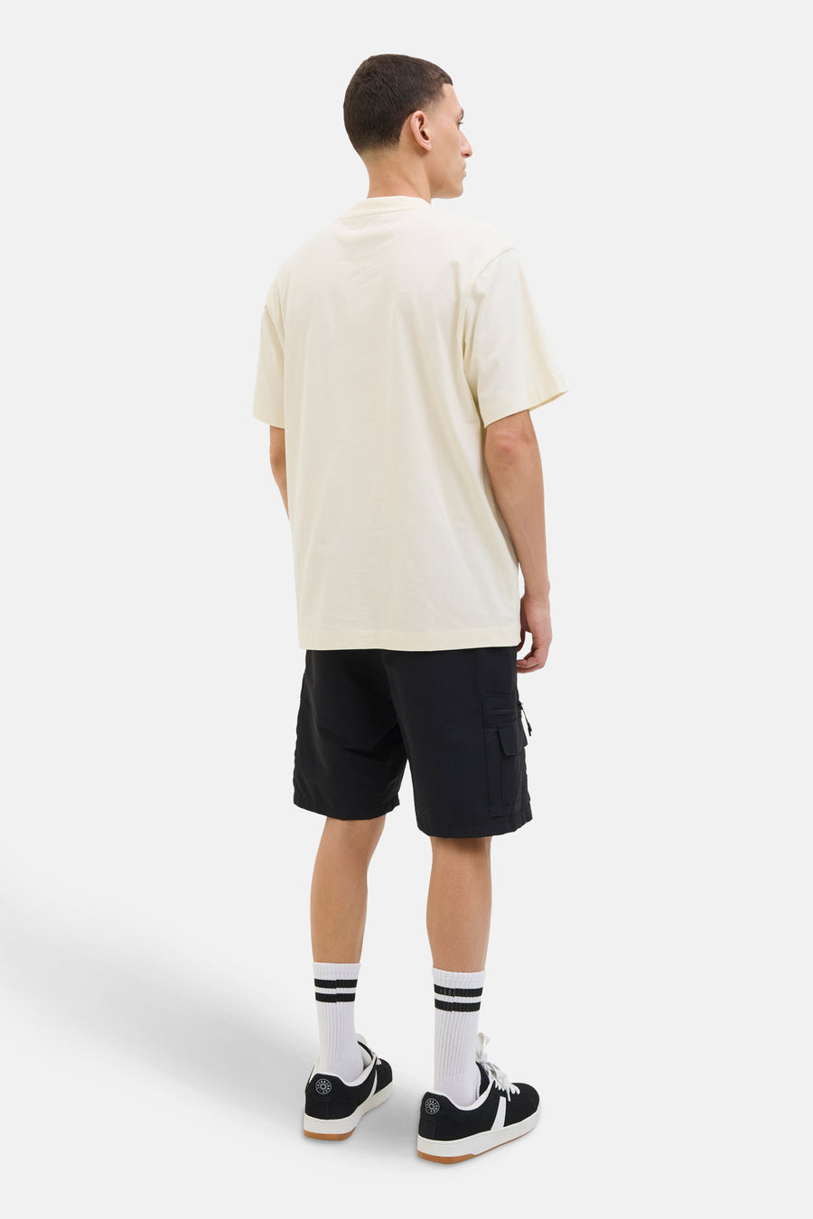 Beige T-shirt met korte mouwen van JACK & JONES, gedragen met een zwarte cargoshort en sportschoenen.
