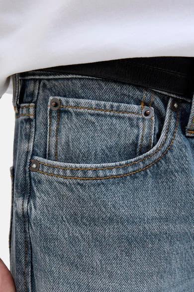 Jean tapered en denim bleu moyen de JACK & JONES, avec poche gousset et surpiqûres contrastées.