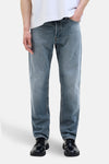 Jean fuselé en denim bleu moyen par JACK & JONES JEANS INTELLIGENCE, porté avec un t-shirt blanc et des chaussures noires.