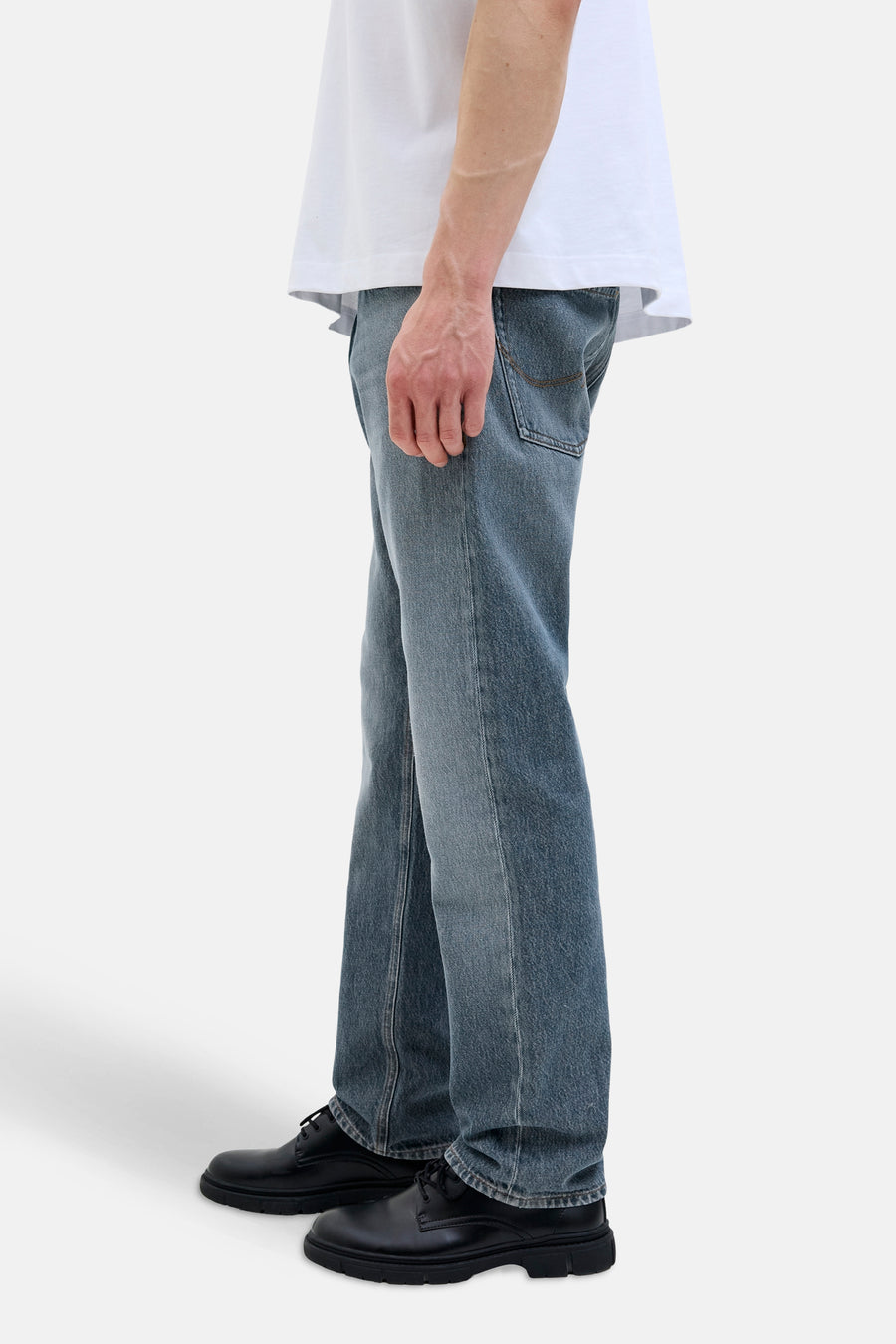 Jean fuselé en denim bleu moyen de JACK & JONES JEANS INTELLIGENCE avec des chaussures noires à lacets.
