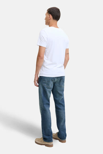 Jean droit en denim bleu moyen de JACK & JONES, porté avec un t-shirt blanc et des chaussures bateau.