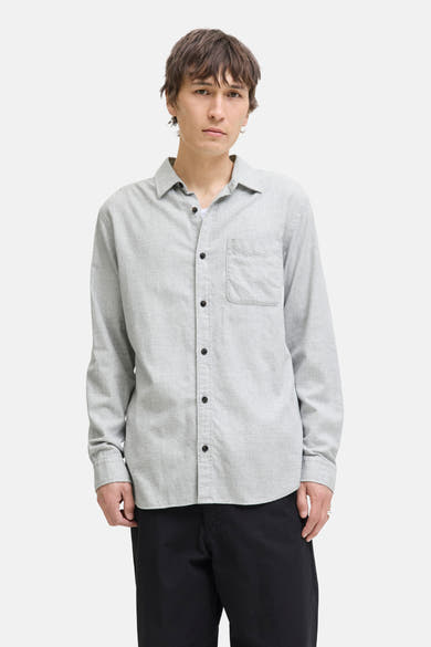 Grijs overhemd met lange mouwen van ORIGINALS BY JACK & JONES, met borstzak en zwarte knopen, gedragen met een zwarte broek.