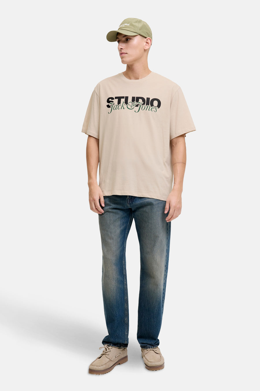 T-shirt à manches courtes écru de ORIGINALS BY JACK & JONES avec imprimé sur le devant, porté avec casquette et jean bleu.
